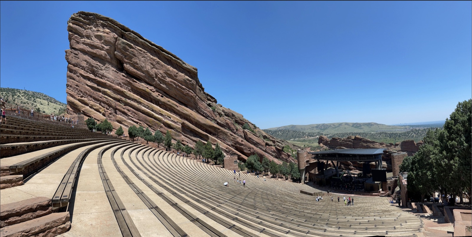 Curved seating at Red Rocks Amphitheatre beside a towering red sandstone formation